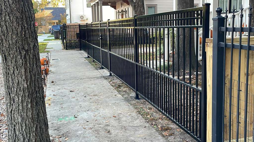 Long black metal fence and coordinated walkway gate