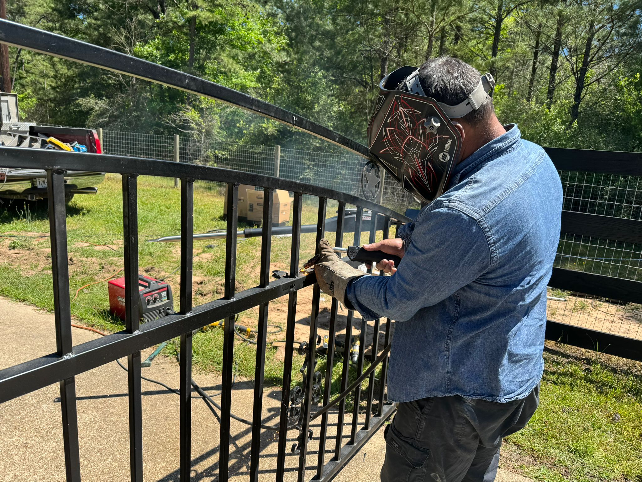 Technician welding a metal automatic gate during repair